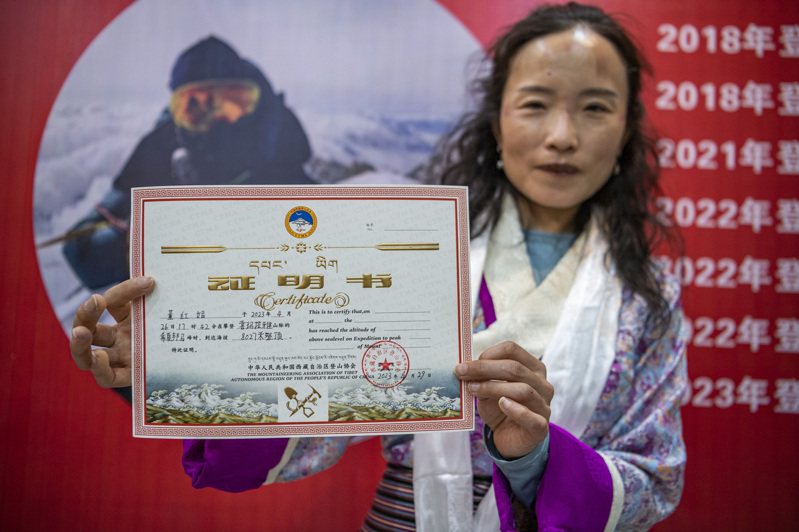 中國登山好手董紅娟登頂全部14座8000米級高峰。圖為董紅娟展示希夏邦馬峰登頂證書。（新華社）