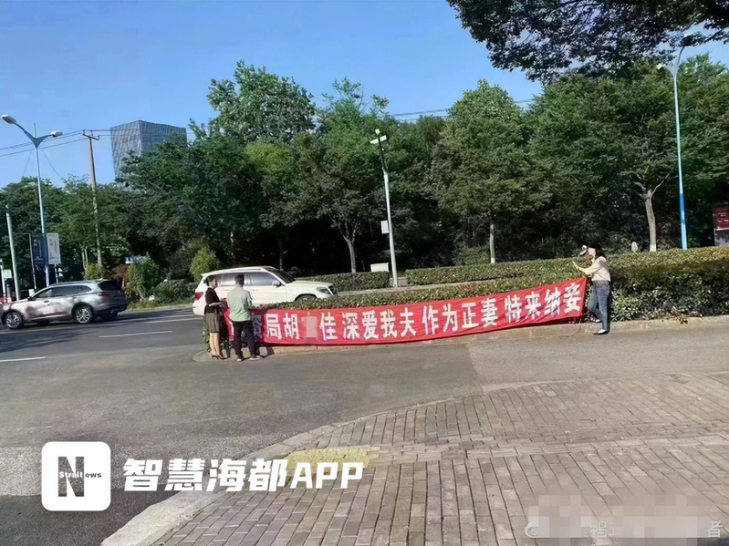 上海青浦區自規局外，有女子拉橫幅「為夫納妾」。（取材自海峽都市報）
