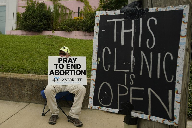 儘管墮胎在20多個州合法、受到保護，但新限制墮胎的法規在法院暫時受阻或遭到訴訟，法律官司正在全國各法院開打。圖為密西西比州傑克遜市一家開業的墮胎診所被民眾舉牌抗議。(美聯社)