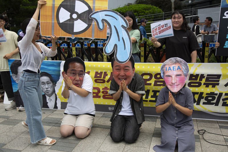 南韓「大學生進步同盟」成員七日在日本駐韓大使館前上演行動劇，（由左至右）戴上日本首相岸田文雄、南韓總統尹錫悅、國際原子能總署署長葛羅西的面具並且下跪，抗議原能署同意日本排放福島核汙水的決定。（歐新社）