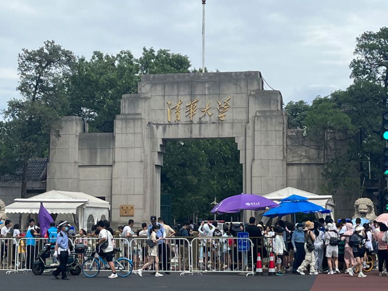 今夏研學營流行參觀北大清華拍照。圖為清華大學西門，遊客在入口處大排長龍。（中通社）