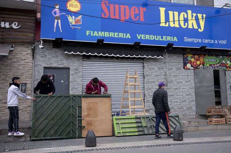 布宜諾斯艾利斯郊區一家超市受到搶劫威脅，老闆在商店入口焊接加固金屬門。 (美聯社)