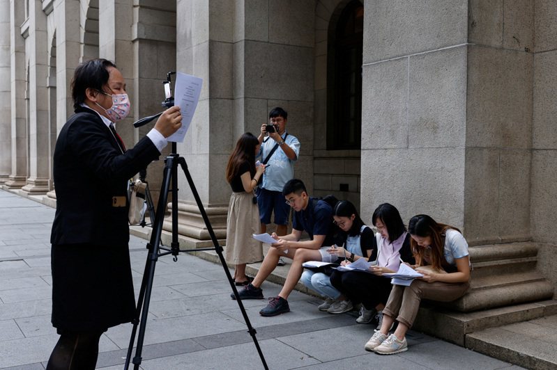香港記者5日在終審法院外，宣讀有關海外同性婚姻的判決。（路透）