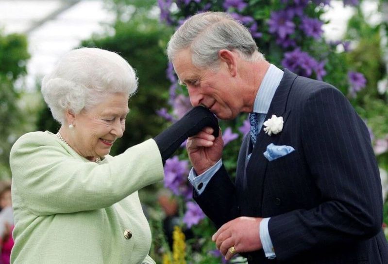 英國國王查理三世即位為王一周年，民調顯示，多數英國人目前對其統治還算滿意；圖為查理三世（右）當年親吻已故女王伊麗莎白的手。（路透）