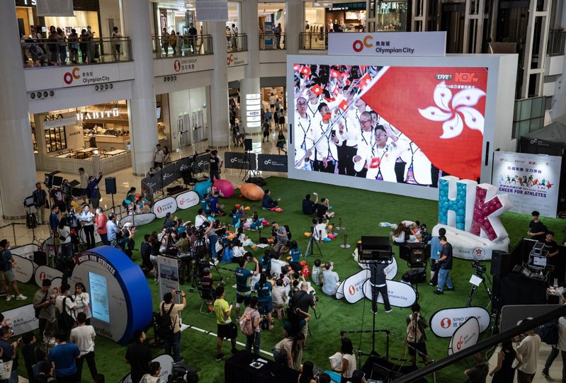第19屆亞洲運動會23日晚間開幕，香港市民在一家大型商場設置的大屏幕前關注開幕式直播實況。（中新社）