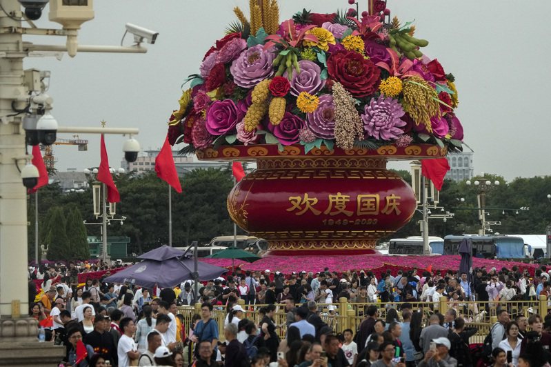十一長假，遊客聚集在北京天安門廣場上的巨型花籃旁，慶祝建政74周年。(美聯社)