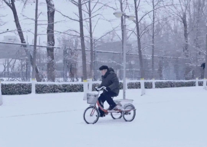 漫天風雪中，89歲高齡的葛昌純院士騎著三輪車前往實驗室，這一幕令不少網友動容。(取材自人民日報)