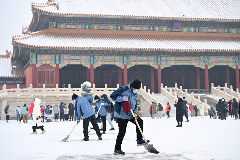北京13日再次迎來大雪天氣，不少遊客前往故宮遊玩賞雪，工作人員忙著努力鏟雪清道。(新華社)