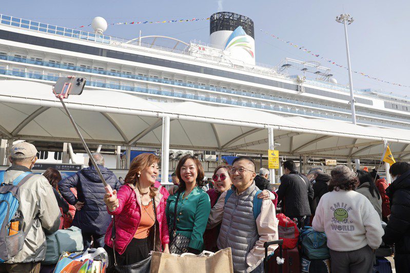 遊客在上海吳淞口國際郵輪港與魔都號合影。(中新社)