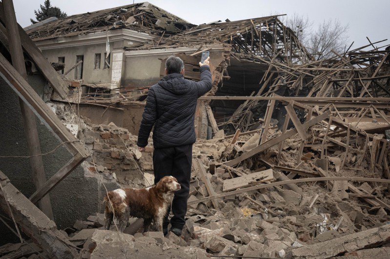 乌克兰斯洛维安斯克（Sloviansk）一名当地居民，在27日夜间，看着被俄罗斯火箭弹袭后的一栋建筑。（美联社）(photo:UDN)