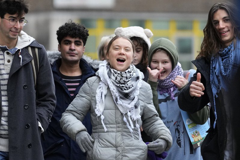 瑞典環保少女童貝里2日與其他抗議者抵達倫敦西敏地方法院時笑開懷。（美聯社）
