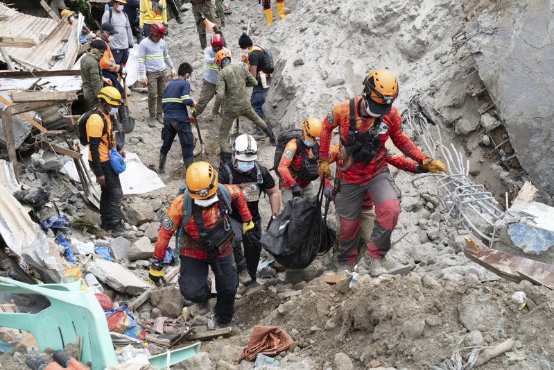 菲律賓南部納卯德奧羅省近日發生土石流，多人失蹤死亡。圖為救難人員運走遺體。（美聯社）