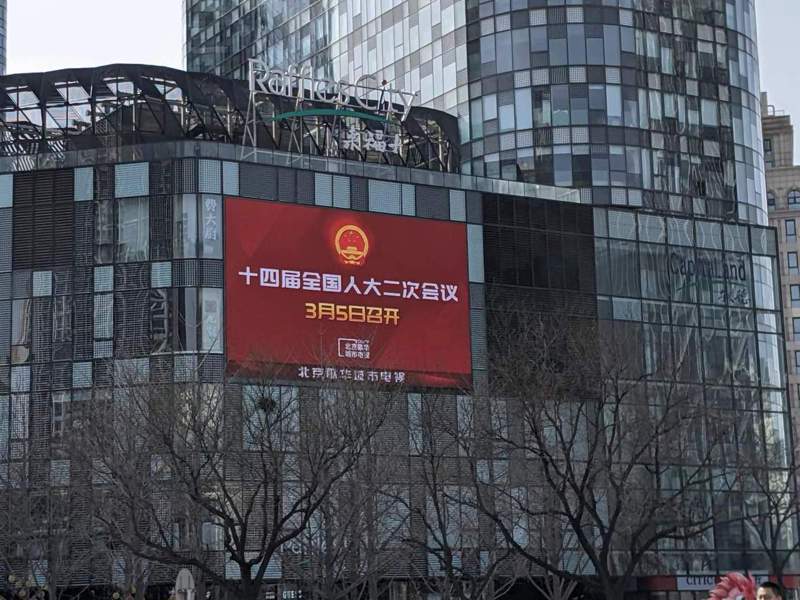 中国2024年两会即将在北京召开，图为北京来福士大楼户外萤幕对两会的宣传。（记者廖士锋／摄影）