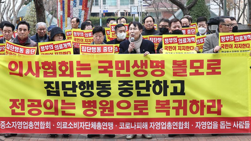 在首爾韓國醫學會前，商業協會成員5日呼籲實習醫生返回醫院。(歐新社)