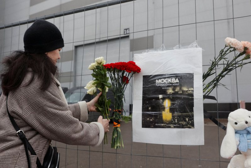 遭逢恐襲的莫斯科近郊番紅花城市大廳前，一名女子23日在臨時設立的默哀地點追悼。(路透)