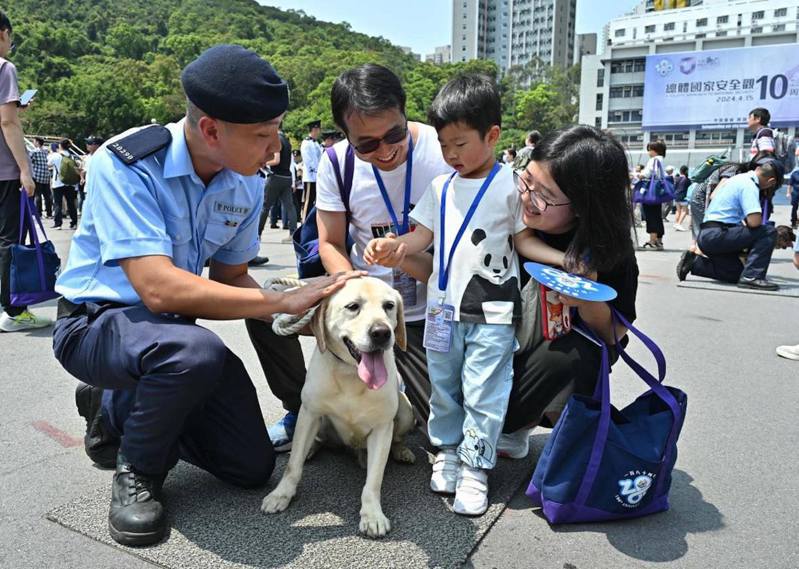 响应全民国家安全教育日，香港警察学院13日开放日活动上，警犬队人员向市民介绍其工作。（新华社）